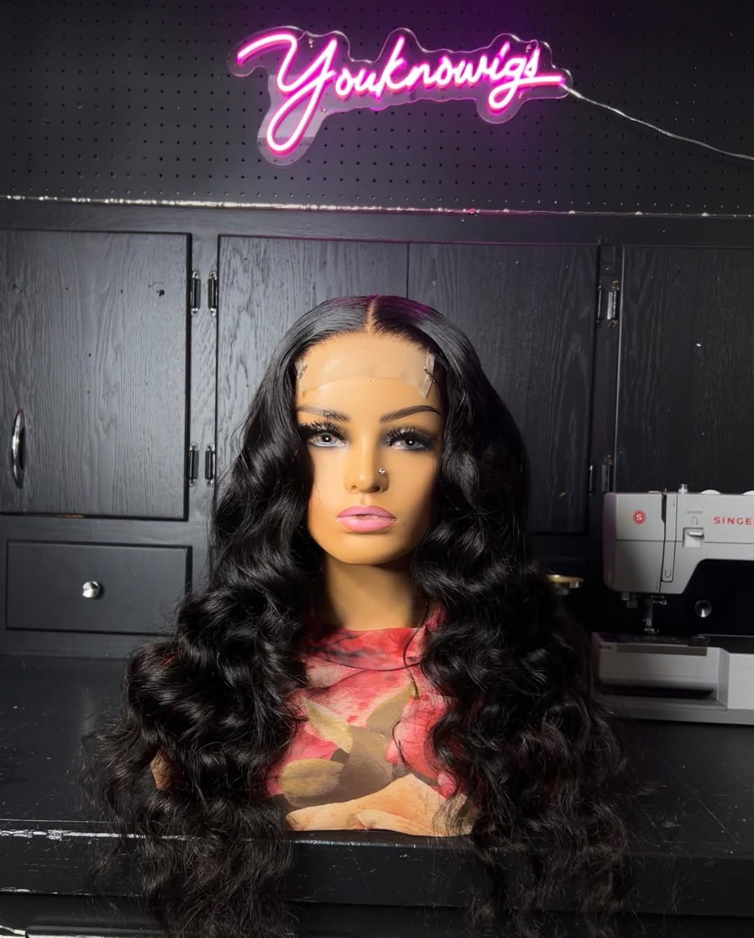 Natural black body wave wig on a mannequin under the neon sign